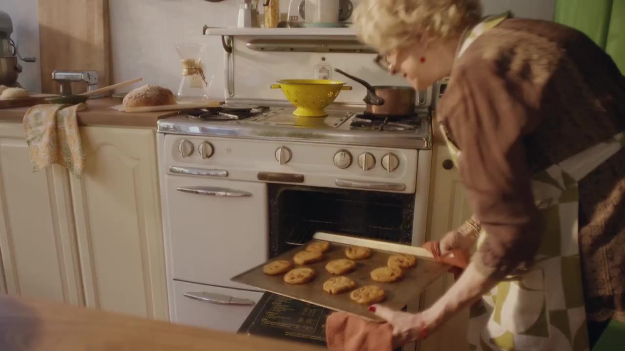 Vrouw haalt een bak met koekjes uit de oven terwijl ze tegen ChatGPT praat, beeld uit de aankondigingsvideo van OpenAI